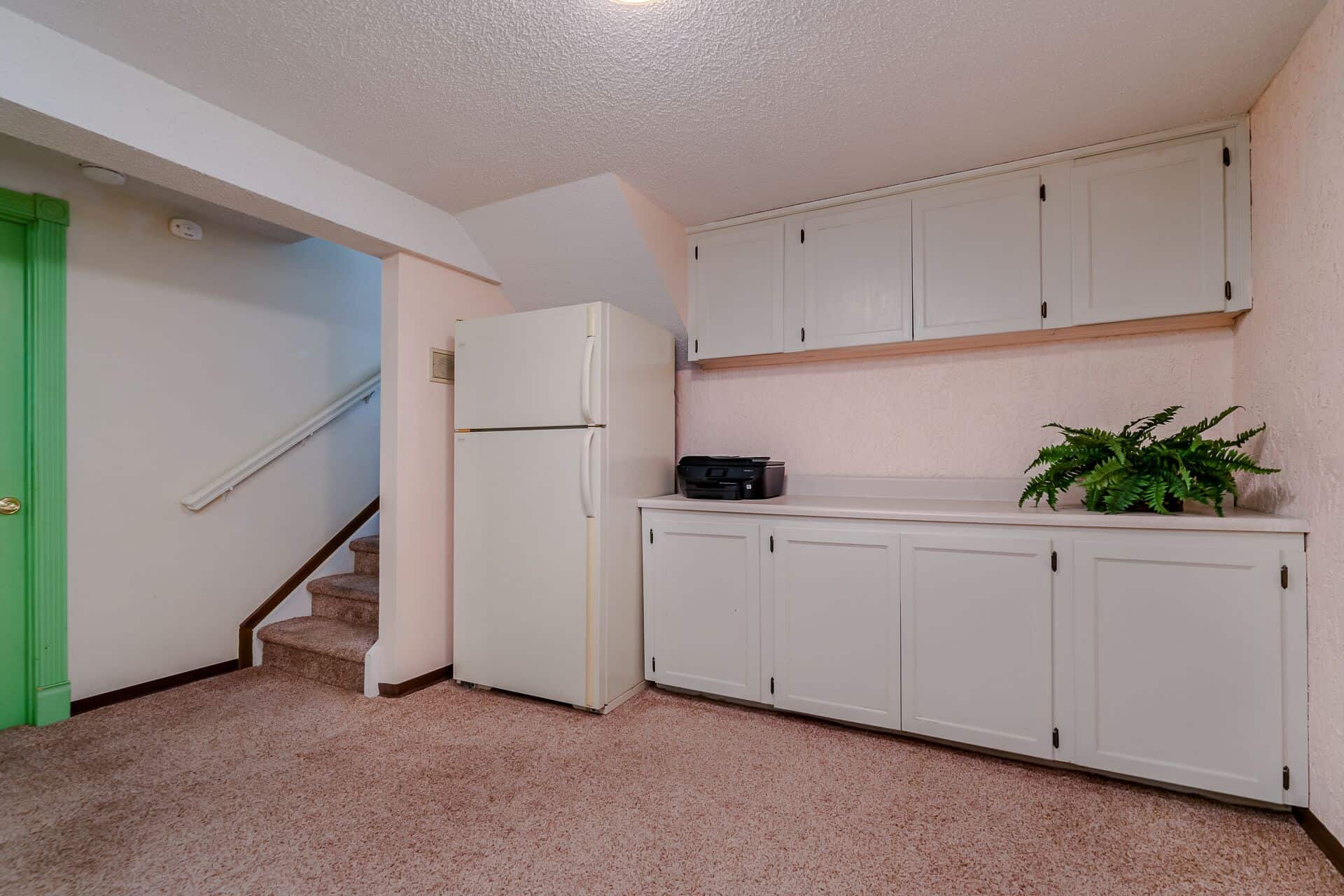 Basement Family Room with Built-In Cabinets and Refrigerator